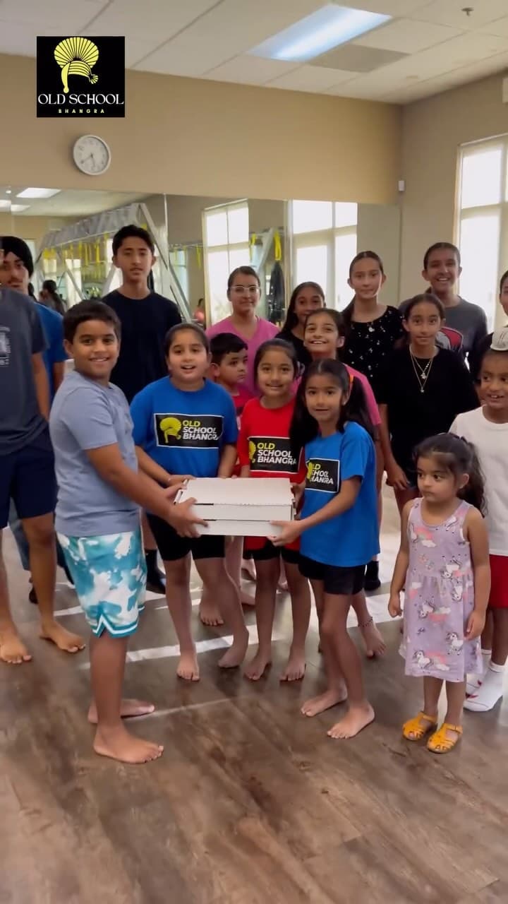 Clickable image showing Curry Pizza distributing pizza's to the little members of Old School Bhangra. Should open an Instagram external link to the source image.